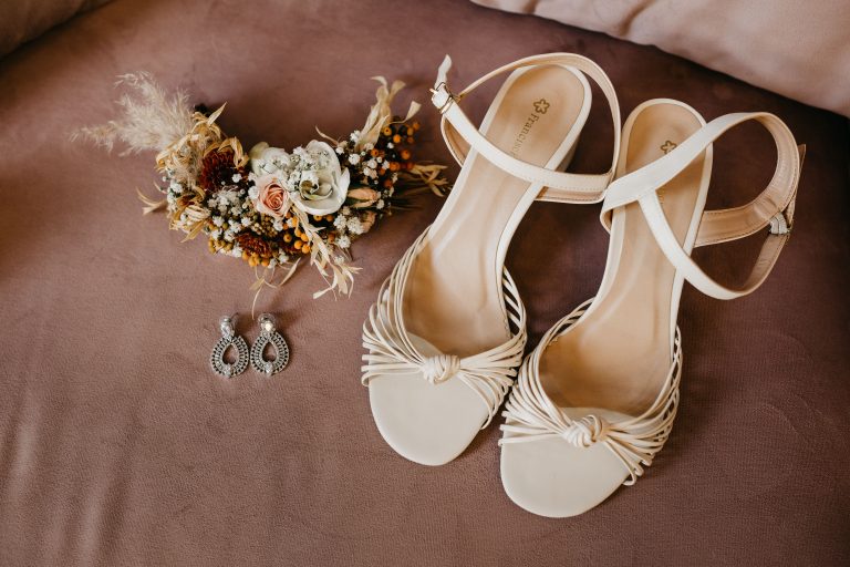 Real wedding photograph of bridal shoes, earrings and floral details